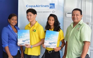 Country Sales Manager, Nadine Oudkerk (left) hands over tickets to Ronald Chang Yuen and Priyanna Ramdhani in presence of Coach Gokarn Ramdhani (right).