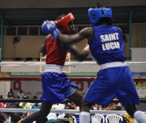 Guyana’s Dewani Lambkin gets in a right upper cut against St Lucian Nathan Ferreri in a Junior Bantamweight fight. (Sean Devers photo)