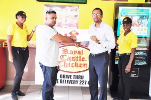 Royal castle General Manager Tribhowan Brasse (2nd right) presents the cheque to Team Xtreme Manager David Bacchus in the presnce of two employees on Thursday at the Sheriff Street outlet.
