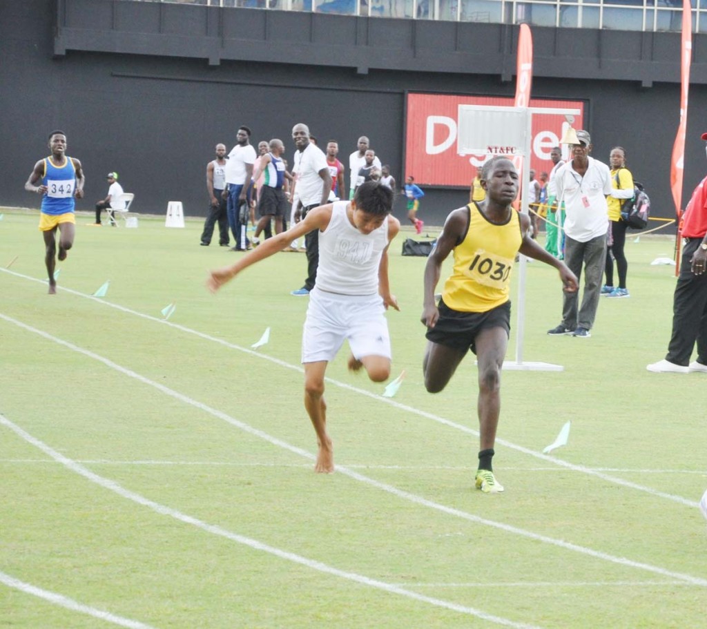 Selwyn Mingo (right) out-leans Francis Ignacio to win the Boys’ 3000m U-16 race yesterday at the National Stadium.