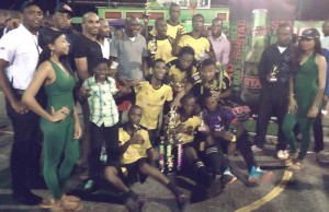 Ansa McAl Stag Beer Manager, Lindon Henry (fourth, right) pose for a photo opportunity with Magic Stars in Linden after the win in the NEE/Stag Futsal Tournament.