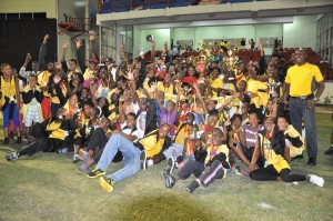 VICTORY! Digicel’s Events and Sponsorship Manager, Louanna Abrams (partially hidden at centre) presents the Championships Trophy to Upper Demerara/Kwakwani last night at National Stadium, Providence.