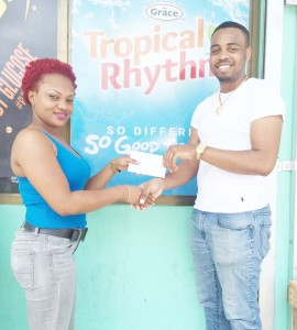 Proprietress of ZSK Beverage Depot, Kelly Quow (left) hands over the sponsorship to Shareef Major yesterday in Linden.  