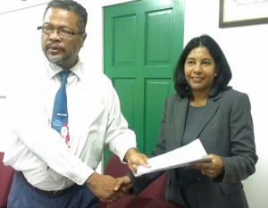 Chief Labour Officer Charles Ogle and DDL Human Resources Director, Moneeta Singh-Bird, shake hands on the agreement. 