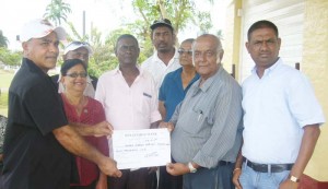 Vice President of the US Chapter, Anthony Dhanie presenting the US$9,000 cheque to President of the Guyana Chapter, George Baijnauth.