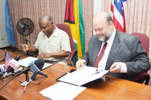 Minister of Foreign Affairs Carl Greenidge and US Ambassador Perry Holloway, affix their signatures to the Caribbean Basin Security Initiative’s (CBSI’s) “Letter of Amendment Three Point Two.” 