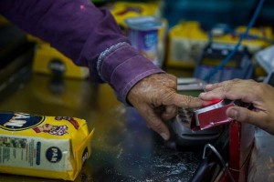 Shoppers have their fingerprints scanned while buying government-controlled corn flour at the “Latino Supermarket” in Maracaibo to prevent them from coming back (Photo source: The Wall Street Journal)