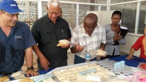 Minister of Agriculture Noel Holder, Permanent Secretary in the Ministry of Agriculture George Jervis and IICA representative, Wilmot Garnett, sample some of the products of the Tapakuma facility during the re-commissioning.
