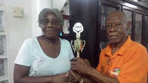 CHANGING OF THE GUARDS: Yvonne Murray gracefully accepts the coveted trophy from her predecessor, Ulric Harris. 