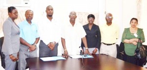 Chief Statistician Lennox Benjamin (center), Managing and Technical Director of Project design and Construction Inc, Aubrey Changlee, (to Benjamin’s left) and other senior members of the Bureau of Statistics following the contract signing.