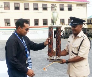2015 Best Cop, DSP Bacchus receives a trophy from a representative of the Roraima Group of Companies. 