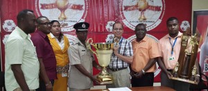 GFA President Clifton Hicken receives the winning trophy from Banks Beer Brand Manager Brian Choo-Hen in the presence of GFA and Banks DIH officials on Thursday.