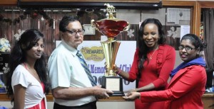 Cecil Kennard receives the Feature race trophy from Metro’s CEO Avia Maria Lindie, while Shivani Sookall (left) and Bibi Farida Alli (right) share the moment. 