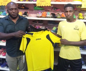 Colours Boutique Marketing Representative Robeson Brotherson left, hands over one of the team jersey’s to player, Daren Benjamin. 