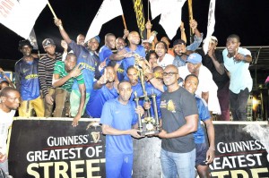 Guinness Brand Manager Lee Baptiste hands over the winning trophy to Sparta Boss Captain Devon Millington in the presence of teammates and supporters early Sunday morning at the National Park.