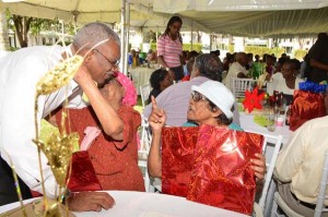 President Granger receives a hug from a senior citizen as other shares conversations