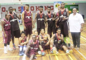 Kwakwani Coach, Ann Gordon (right) poses with her successful basketball team Sunday at the Cliff Anderson Sports Hall.