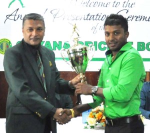  Male Cricketer of the Year Veerasammy Permaul is presented with his trophy by WICB Director Anand Sanasie.