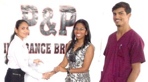 Ms. Subrena Ishmile (left) of P&P Insurance Brokers and Consultants Ltd. Hands over the sponsorship to GSSF President, Ms. Vidushi Persaud in the presence of GSSF Board Member, Dr. Pravesh Harry.