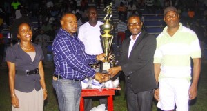 Director of the Petra Organisation Troy Mendonca (2nd left) hands over one of the trophies to UDFA President Sharma Solomon in the presence of members of the executive last Sunday at the MSC ground.