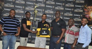 Sparta Boiss Captain Devon Millington (2nd left) receives the team’s monetary prize, trophy and Guinness bags from Guinness representative Shawn Stephney in the presence of Company officials yesterday.
