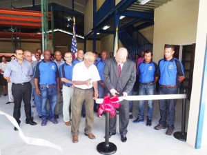 The ceremonial ribbon-cutting being performed at the new Warehouse by Mr. Toolsie Persaud and US Ambassador Perry Holloway.