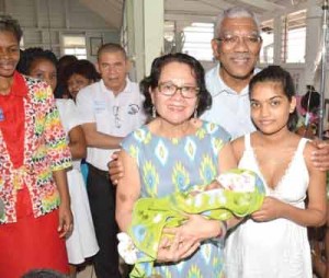 The President and First Lady pose with Herstelling mom, Cassie Baksh and her new baby.