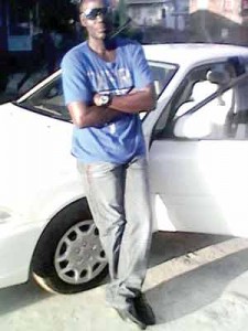 Lebert Thomas standing next to the car that the robbers tried to take away before he was shot.