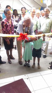 (From left) Minister Roopnaraine cutting the ribbon with a student at the Cummings Park Nursery School in Sophia. 
