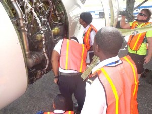 Some of the students examining a turbine engine on a Caribbean Airlines aircraft.