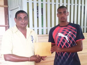 Distance athlete, Lionel D’Andrade (right) receives his sponsorship package from a staffer of the Builders Lumber Yard yesterday.