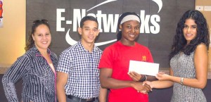 Marketing Manager of E-Networks Macaela Cameron (right) hands over the sponsorship cheque to Noshavyah King, one of the organisers of the E-Networks Cross Fitness Challenge, in the presence of Jordana Ramsay-Gonsalves and Jamie McDonald recently.