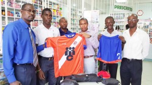 Aaron Fraser of Medicine Chest (3rd right) hands over the U-17 Elite League kits and uniforms to Club Secretary Daniel Thomas in the presence of club officials and  GFF TDO) Lyndon France (right) yesterday.