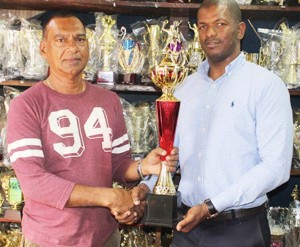 Proprietor of Trophy Stall, Ramesh Sunich (left) hands over one of the trophies to President of GTTA, Godfrey Munroe.
