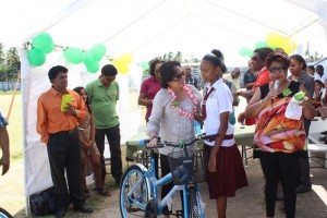 First Lady, Mrs. Sandra Granger comforts this student who burst into tears of joy upon receiving her bicycle, this morning, at the Scottsburg Community Centre Ground. 