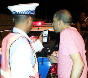 A member of the Traffic Task Force administers the breathalyzer test to a motorist.