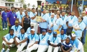 Hubern Evans (left), captain of YWCC collects the winning trophy from Mukesh Appiah, son of Ramnarine Appiah while other family members and cricketers share the moment. 