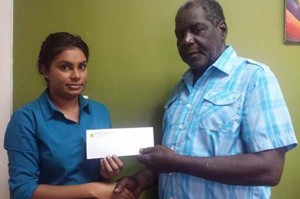 In this photo, Lloyd Grant receives the cheque from Ms Yussuf yesterday morning at her Beterverwagting office.
