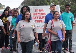 Minister of Social Protection Volda Lawrence and members of the Queens College student body trending under #BURNTHEPRICETAG, during the walk an initiative aimed at stopping Trafficking in Persons.