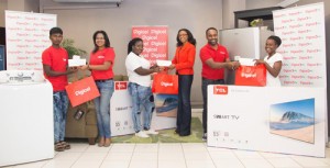 Digicel's Head of Marketing, Ms. Jacqueline James, Advertising Manager, Ramesh Rupchand  and Communications Manager Vidya Sanichara, present prizes and cheques to those winners  who were lucky to find both cash and appliances in the Merry Mansion. 