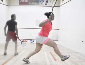 Andrea King hits a forehand shot off the wall in her losing effort against Steven Xavier at the GT Club on Tuesday night.