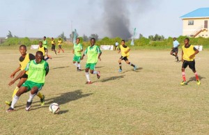 A player from Chase Academic Foundation (green bib) shields the ball from a challenge by an East Ruimveldt player during their encounter yesterday.
