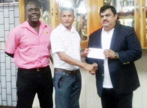  Dave Narine of Dave West Indian Imports presents the sponsorship to Anand Sanasie (centre) of the GCB while Colin Stuart looks on. 