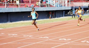 Fourteen-year-old sprint phenom, Kenisha Phillips (left) comfortably eases at the finish line with a sizeable victory in the U-18 Girl’s 200m, taking a glance at nearest rival Avon Samuels, which cemented her dominance.