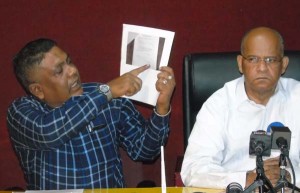PPP MP, Zulficar Mustapha, points to some of the names on his list yesterday. To the right is PPP General Secretary Clement Rohee