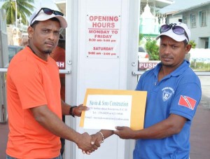  Marshall Karamchand (left) presents the cheque to Lakeram Dindyal of WBCA. 