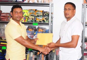 Zaheer Mohamed (left) accepts the cheque from Regal Sports Sales Representative Richard Latif. 