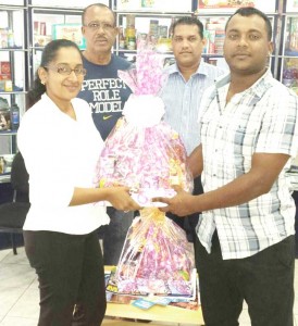 Roxan Prahalad (left) hands over hampers to Waheid Edwards, captain of YWCC in the presence the team coach Hubern Evans and Wazim Ali.