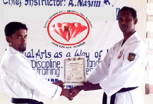 Instructor Ryan Daniels (left) receives his Certificate of Authorization from Shihan Abdool Nazim Yassim.