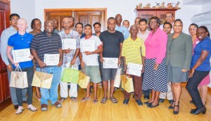 From left: Six graduates of the Sterling Products Ltd Literary Programme, Assistant Chief Education Officer Leslyn Charles and at far right in the last row, CEO of Sterling Products Ltd, Ramsay Ali.